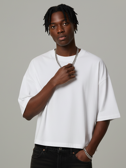 Person wearing a white t-shirt and black pants against a gray background