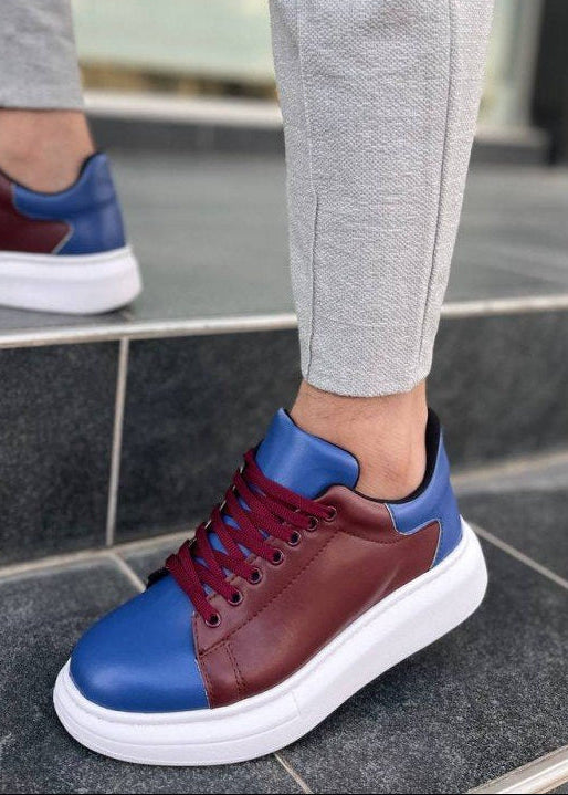 Person wearing maroon and blue sneakers on a stone floor.