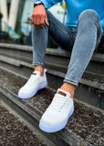 Person wearing white sneakers and blue jeans sitting on steps.