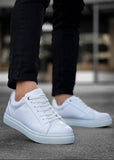 White sneakers worn with black pants on a blurred background