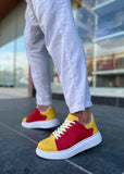 Red and yellow sneakers worn on a person's feet with a blurred background