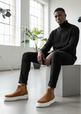 Man in black turtleneck and pants wearing Avalon Brown ribbed Chelsea Apollo Moda boots.