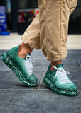 Man wearing Torino Green Peak White Mesh sneakers with green gradient and white splatter design.