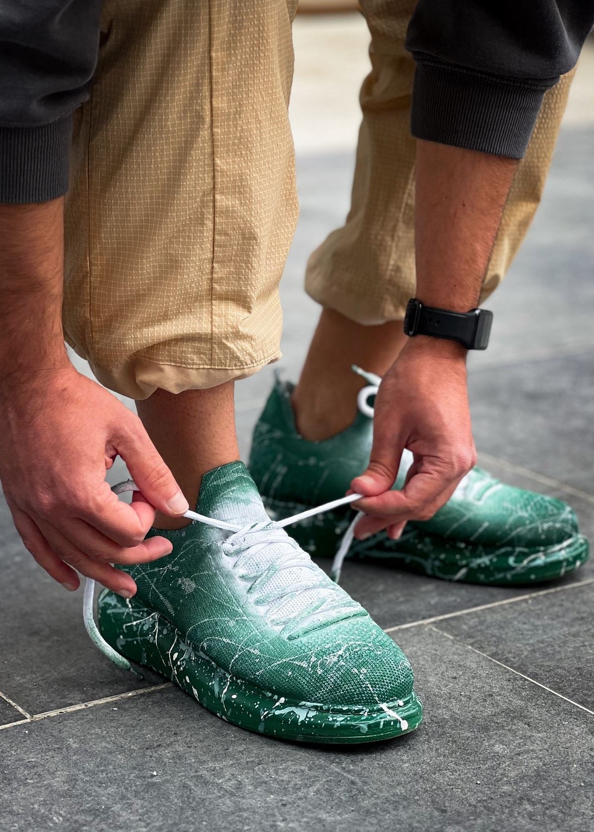 Man wearing Torino Green Peak White Mesh sneakers with green gradient and white splatter design.