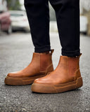 Man wearing Avalon Light Brown Chelsea boots with cushioned platform sole on wet pavement.