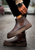 Close-up of Avalon Coffee Brown Chelsea boots worn outdoors on wet pavement.